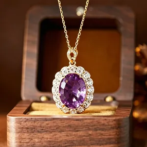 Gros plan d'un pendentif en améthyste ovale avec taille millénium dans un écrin en bois noble.