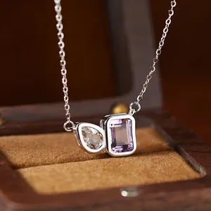 Detail view of S925 silver necklace with pear-cut topaz and rectangular amethyst stone