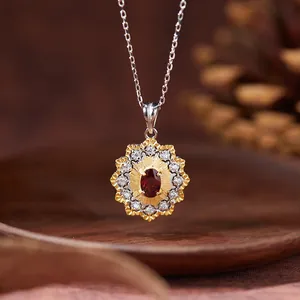 Macro view of vintage floral garnet pendant necklace with gold and silver accents