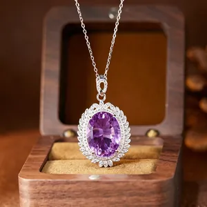 Macro detail of a large oval purple amethyst pendant necklace in a luxury wood box