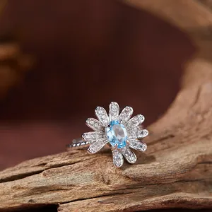 Nahaufnahme von Gänseblümchen-Ring aus S925 Silber mit hellblauem Topas-Edelstein