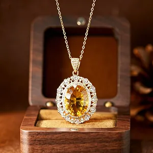 Close-up of elegant gold oval citrine pendant necklace with halo stones and wooden box