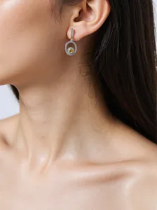 Close-up of elegant S925 silver drop earrings with a bright yellow gemstone.
