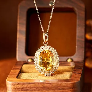 Close-up detail of a large oval citrine pendant elegantly set in a golden sunburst.