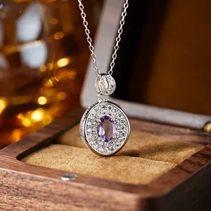 Close-up of a circular S925 sterling silver pendant with an oval amethyst stone.