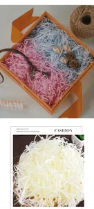 Colorful shredded paper raffia filler for gift boxes in pink, blue and ivory.