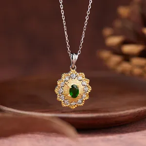 Close-up of elegant emerald sunflower pendant necklace with gold textured setting
