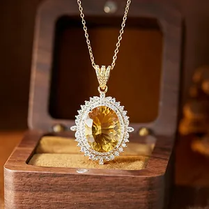 Detailed macro view of a large oval-cut yellow citrine pendant in a vintage wooden box