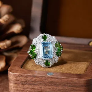 Vue macro d'une bague vintage en argent S925 avec topaze bleue et gemmes vertes.