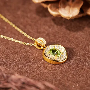 Detail view of S925 sterling silver necklace with oval green gemstone and zircon halo.