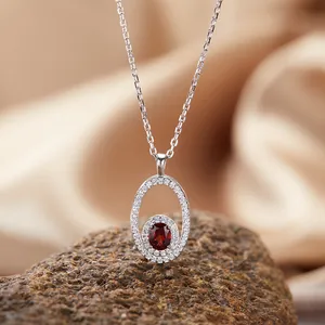 Macro detail of S925 silver necklace with oval red garnet and pavé stones pendant