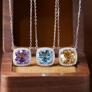 Close-up detail of S925 silver pendants with amethyst, topaz, and citrine in a wooden jewelry box.