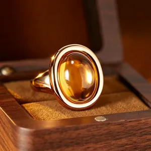 Detailed macro view of a citrine bathtub ring with 24K gold plating in a wooden box