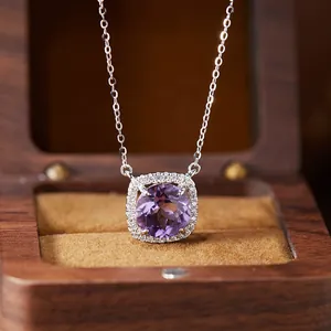 Close-up of a premium sterling silver necklace with a halo-set purple amethyst pendant