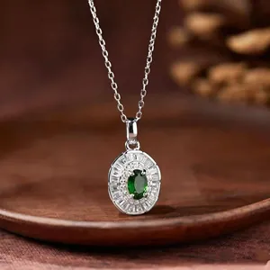 Nahaufnahme einer eleganten S925 Silberkette mit ovalem grünen Edelsteinanhänger