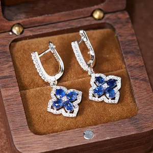 Nahaufnahme von Vintage S925 Silbeohrringen mit blauen kleeblattförmigen Edelsteinen in Box