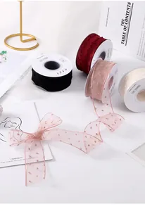 Detailweergave van diverse transparante en fluwelen linten met een roze mesh strik