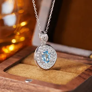Close-up of S925 sterling silver necklace with blue topaz pendant in wooden gift box