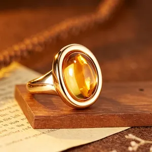 Beautiful close-up of a 24K gold-plated ring featuring a large oval yellow gemstone