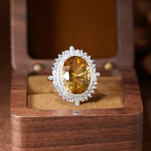 Macro view of large oval citrine pendant with silver halo in a wooden gift box