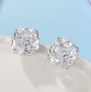 Close-up of white crystal stud earrings with silver prongs and multi-faceted cut