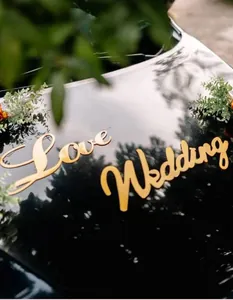 Nahaufnahme der goldenen Love Wedding Buchstaben Dekoration auf einer Autohaube.