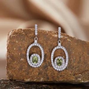 Detail view of S925 silver halo earrings featuring oval-cut green peridot gemstones