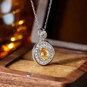 Close-up of citrine pendant necklace with sparkling crystal halo in a wooden box