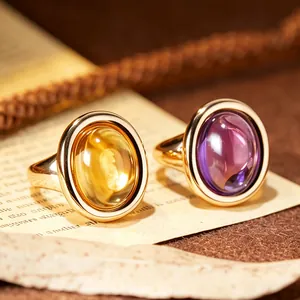 Close-up of vintage gold rings with natural oval citrine and purple amethyst gemstones.
