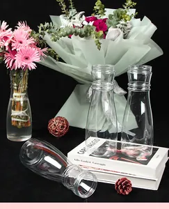 Detailed view of transparent bouquet holders arranged with flowers on art books