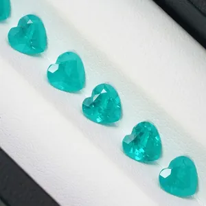 Detailed view of vibrant heart-cut Paraiba teal synthetic gemstones displayed in a gift box