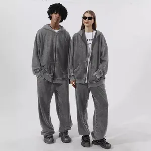 Detailed look at distressed grey zip-up hoodie and matching joggers set on models