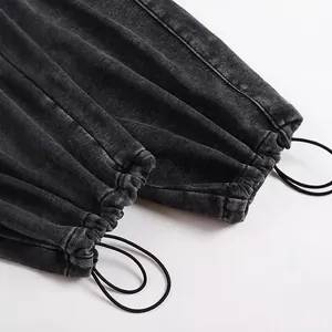Close-up of the adjustable elastic drawstring hem on washed grey men's joggers pants