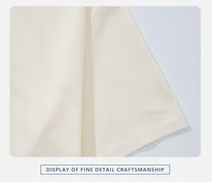 Macro view of cream cotton T-shirt sleeve showcasing high-quality double stitching