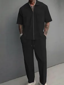 Full-length shot showing the fit of the men's black leisure set with zipper collar.