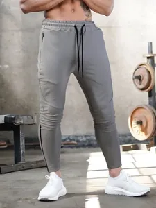 Detailansicht der grauen Herren-Sport-Jogginghose in einer professionellen Fitnessumgebung.