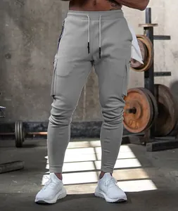 Close-up of grey men's joggers with multi-pocket design in a gym setting