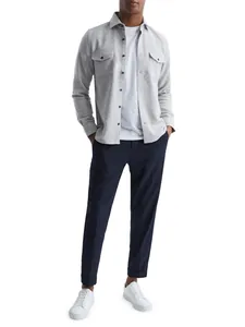 Men's light grey casual shirt jacket with chest pockets over white tee and navy trousers