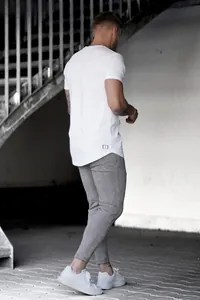 Vue arrière d'un mannequin portant un pantalon de jogging ajusté à carreaux gris en ville.