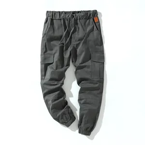 Detailed view of grey cotton cargo pants with drawstring waist and multi-pockets