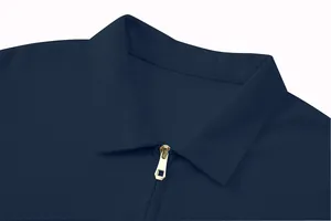 Close-up of navy men's polo shirt with gold zipper and textured jacquard pattern.
