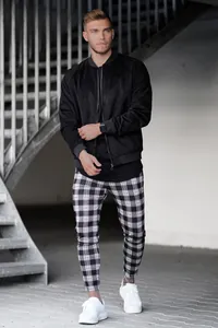 Vue complète du pantalon décontracté ajusté à carreaux noir et blanc pour homme urbain