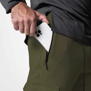 Detail view of men's olive green sports joggers with a functional secure zipper pocket.