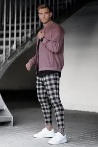 Mannequin masculin portant un pantalon à carreaux noir et blanc avec des baskets blanches