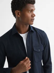 Close-up detail of a navy blue men's casual shirt jacket featuring flap chest pockets