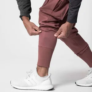 Close-up detail of maroon men's athletic joggers with ribbed cuffs and elastic fabric