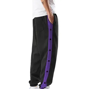 Detailweergave van de drukknopen op de paarse zijstreep van deze heren sportbroek.
