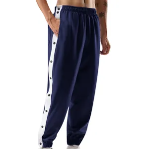 Detailweergave van de donkerblauwe herensportbroek met witte strepen en drukknopen