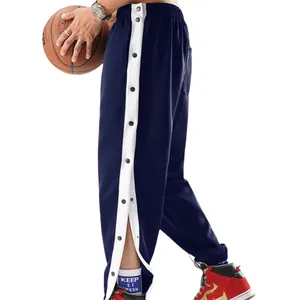 Detail van de blauwe sportbroek met witte zijstreep en functionele drukknopen