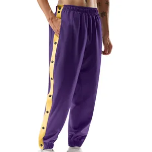 Detail van paarse joggingbroek met gele zijstrepen en zwarte functionele drukknopen